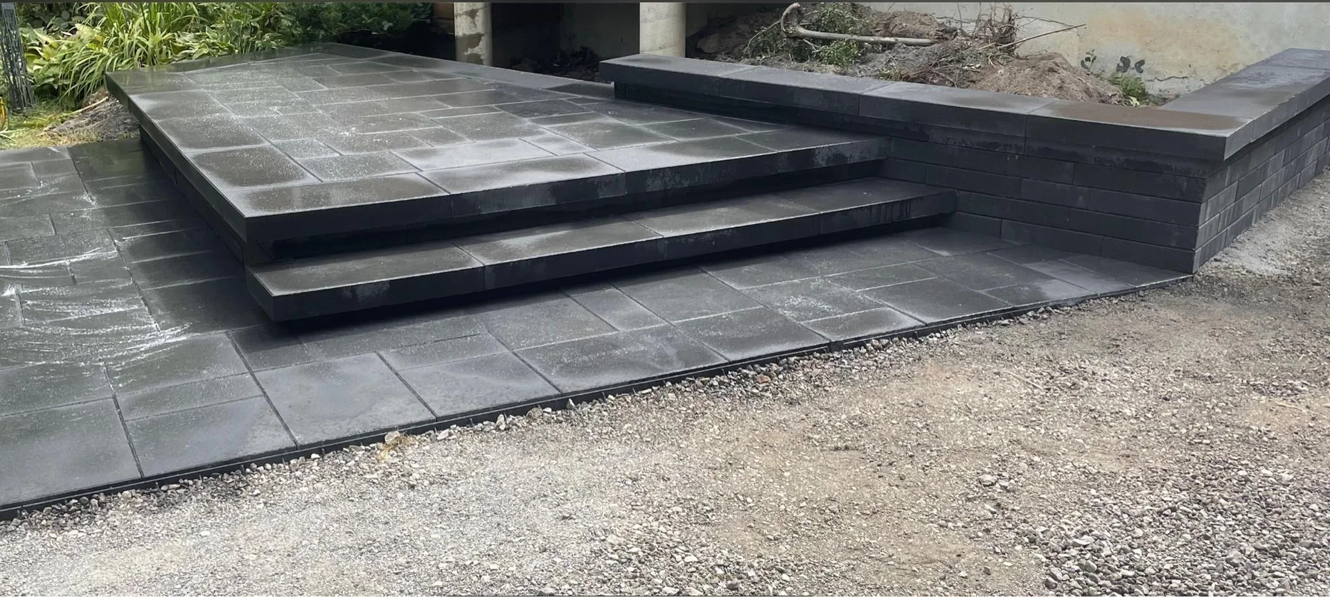 Large palier en pavé et dalles foncées avec marches intégrées
