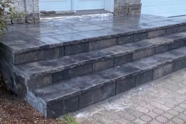 Palier extérieur avec structure de béton intégrée à un aménagement en pavé